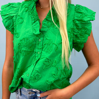 Green textured blouse worn by a person on a plain background