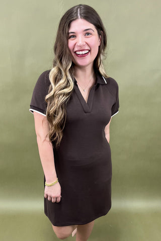 Woman wearing a brown dress with a green background
