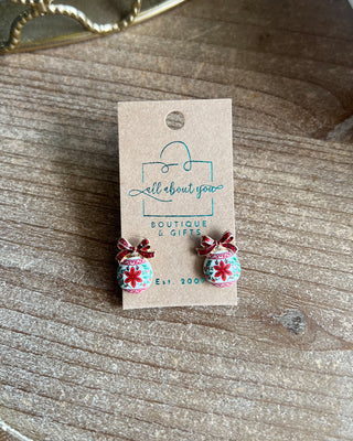 Shop the Christmas Ball Ornament Earrings at All About You Boutique! Festive white ornaments with red glitter bows and floral details. Perfect for holiday outfits.