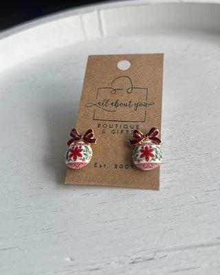 Shop the Christmas Ball Ornament Earrings at All About You Boutique! Festive white ornaments with red glitter bows and floral details. Perfect for holiday outfits.