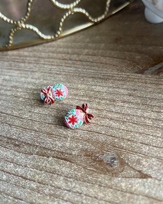Shop the Christmas Ball Ornament Earrings at All About You Boutique! Festive white ornaments with red glitter bows and floral details. Perfect for holiday outfits.