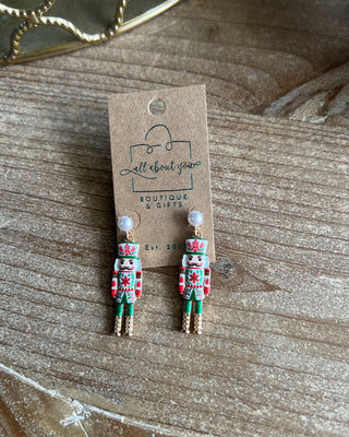 Shop the Nutcracker Pearl Drop Earrings at All About You Boutique! Festive Christmas earrings with faux pearl studs, floral nutcrackers, and gold accents.