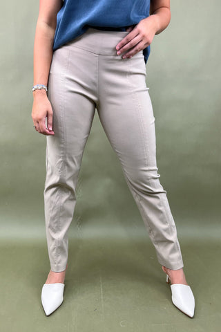 Person wearing beige pants and white shoes on a green background