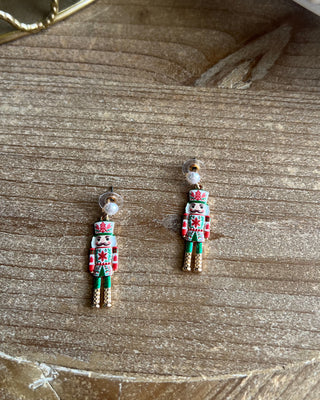 Shop the Nutcracker Pearl Drop Earrings at All About You Boutique! Festive Christmas earrings with faux pearl studs, floral nutcrackers, and gold accents.