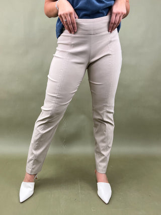 Person wearing light gray pants and white shoes on a green background