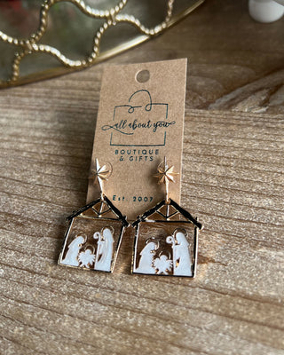 Shop the Nativity Scene Gold Drop Earrings at All About You Boutique! Beautiful gold and white Christmas earrings featuring Mary, Joseph, and baby Jesus.