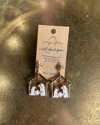 Shop the Nativity Scene Gold Drop Earrings at All About You Boutique! Beautiful gold and white Christmas earrings featuring Mary, Joseph, and baby Jesus.