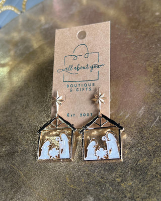 Shop the Nativity Scene Gold Drop Earrings at All About You Boutique! Beautiful gold and white Christmas earrings featuring Mary, Joseph, and baby Jesus.