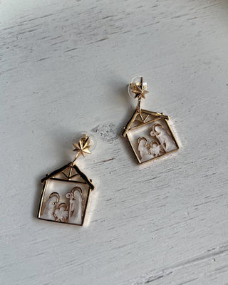 Shop the Nativity Scene Gold Drop Earrings at All About You Boutique! Beautiful gold and white Christmas earrings featuring Mary, Joseph, and baby Jesus.