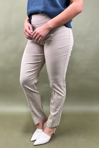 Person wearing beige pants and white shoes on a green background