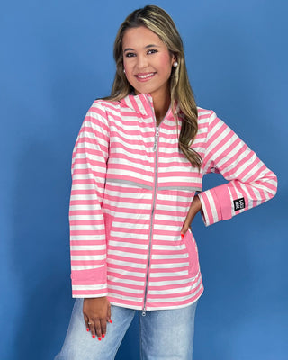 Woman wearing a pink and white striped jacket against a blue background