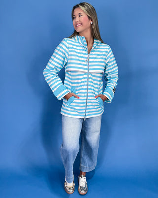 Woman wearing a blue and white striped jacket against a blue background