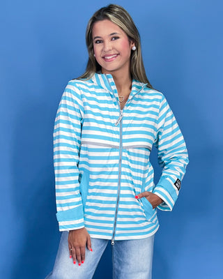 Woman wearing a blue and white striped jacket against a blue background
