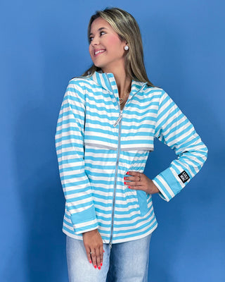 Woman wearing a blue and white striped jacket against a blue background