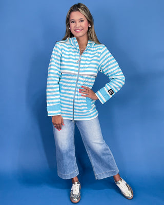Woman wearing a blue and white striped jacket on a blue background