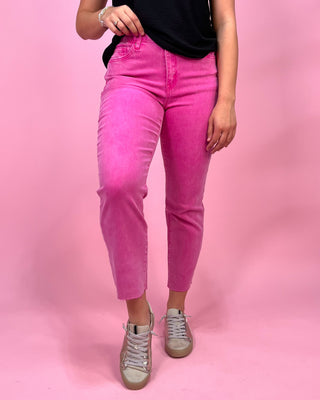 Person wearing bright pink jeans on a pink background