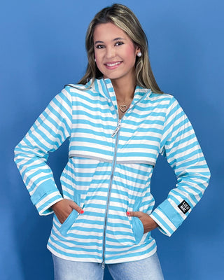 Woman wearing a blue and white striped jacket against a blue background