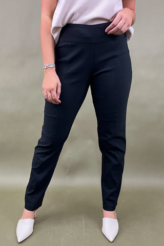 Person wearing black pants and white shoes on a plain background