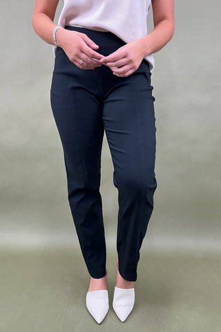 Person wearing black pants and white shoes on a plain background