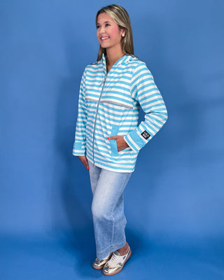 Woman wearing a blue and white striped jacket against a blue background