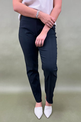 Person wearing navy pants and white shoes on a plain background