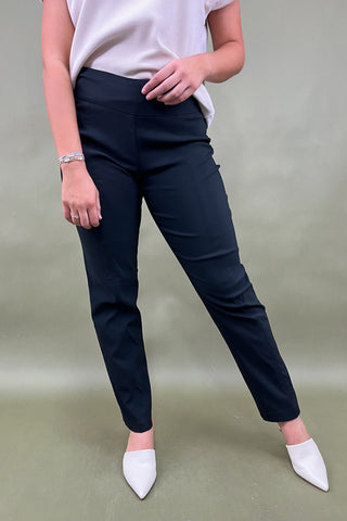 Person wearing navy pants and white shoes on a plain background