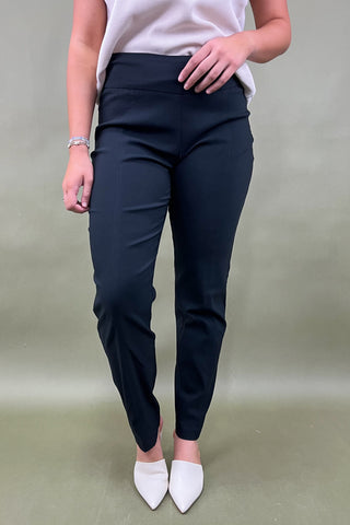 Person wearing navy pants and white shoes on a plain background