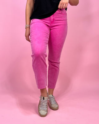Person wearing bright pink jeans on a pink background