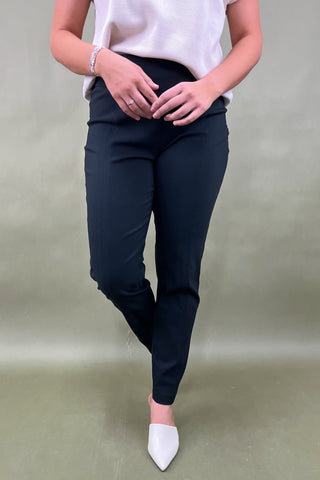 Person wearing navy pants and white shoes on a plain background