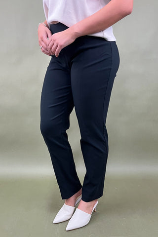 Person wearing black pants and white shoes on a plain background