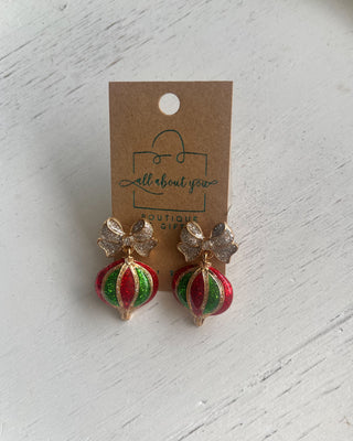 Shop the Holiday Ornament Bow Accent Earrings at All About You Boutique! Sparkling silver bows and red and green glitter ornaments bring festive Christmas charm.