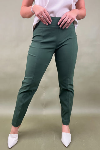 Person wearing green pants and white shoes on a plain background