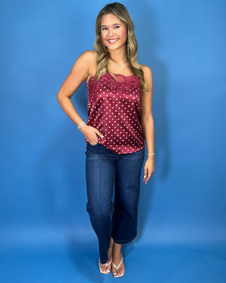 Burgundy satin polka dot camisole with delicate lace trim, thin straps, and a feminine relaxed fit.