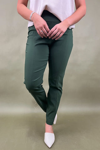Person wearing green pants and white shoes on a plain background