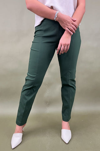 Person wearing green pants and white shoes on a plain background