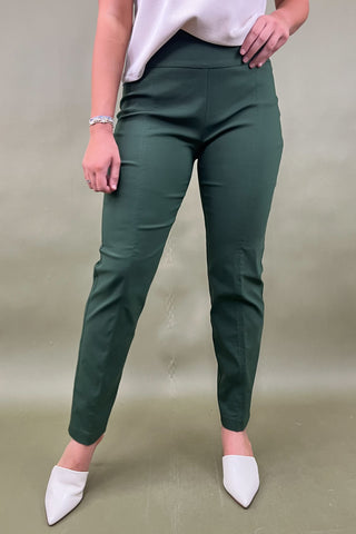Person wearing green pants and white shoes on a beige background