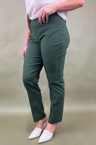 Person wearing green pants and white shoes on a beige background