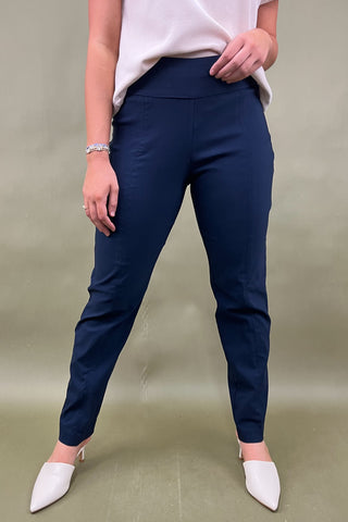 Person wearing navy pants and white shoes on a plain background