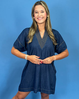 Woman wearing a blue dress against a blue background
