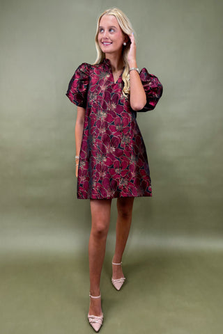 Woman wearing a floral dress against a green background