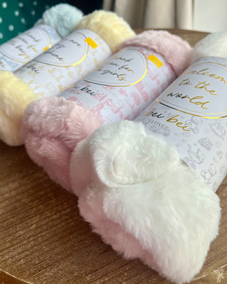 Shop the Bei Bei Faux Fur Lovey in blue, pink, yellow, and ivory. Soft, fluffy baby loveys with sweet messages, perfect for baby showers and newborn gifts.