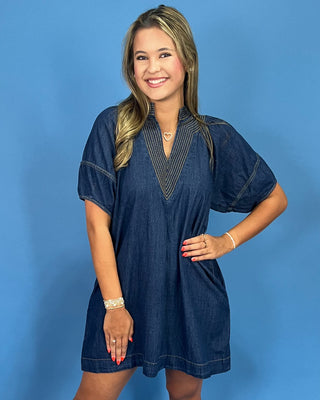 Woman wearing a blue dress against a blue background