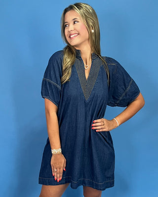 Woman wearing a blue dress against a blue background