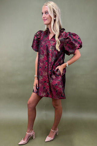 Woman wearing a patterned dress against a green background