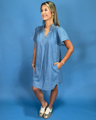 Woman wearing a blue dress against a blue background