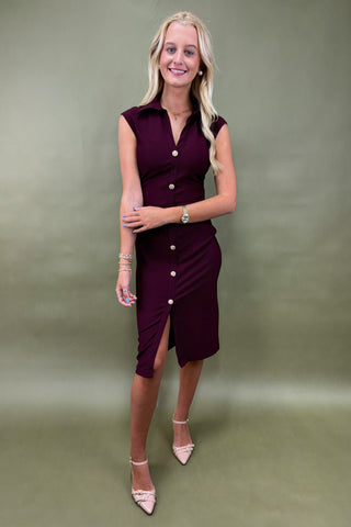 Woman wearing a burgundy dress with a green background