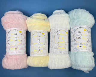 Shop the Bei Bei Faux Fur Petite Blanket in pink, blue, yellow, and white. A soft, fluffy baby blanket perfect for newborn gifts and baby showers.