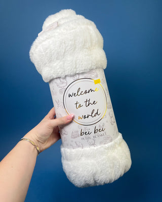 Shop the Bei Bei Faux Fur Petite Blanket in pink, blue, yellow, and white. A soft, fluffy baby blanket perfect for newborn gifts and baby showers.