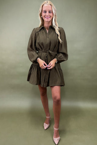 Woman wearing a green dress against a matching background