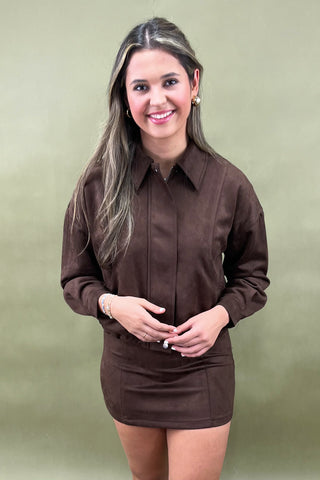 Woman wearing a brown dress against a green background